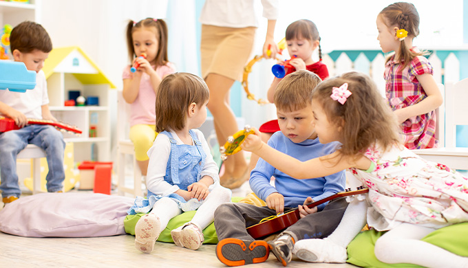 Photo d'enfant qui jouent entre eux avec une professionnelle de la petite enfance