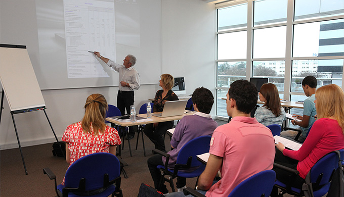 Photo de personnes dans une salle écoutant un formateur